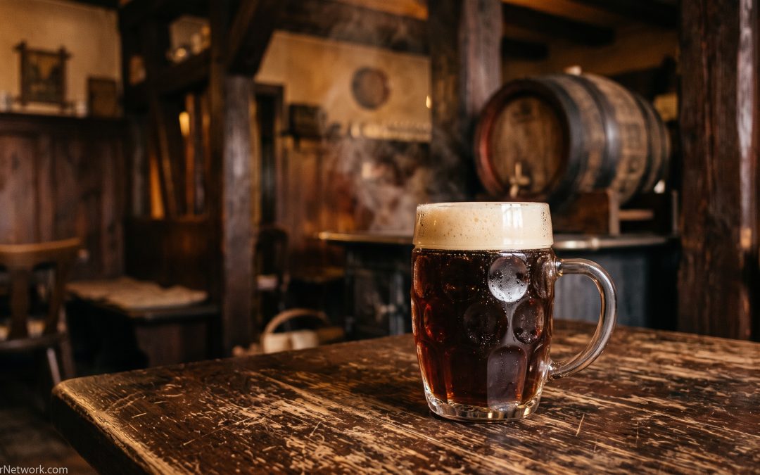 Mug of dark smoked lager on a wooden table in a historic Bamberg-style tavern
